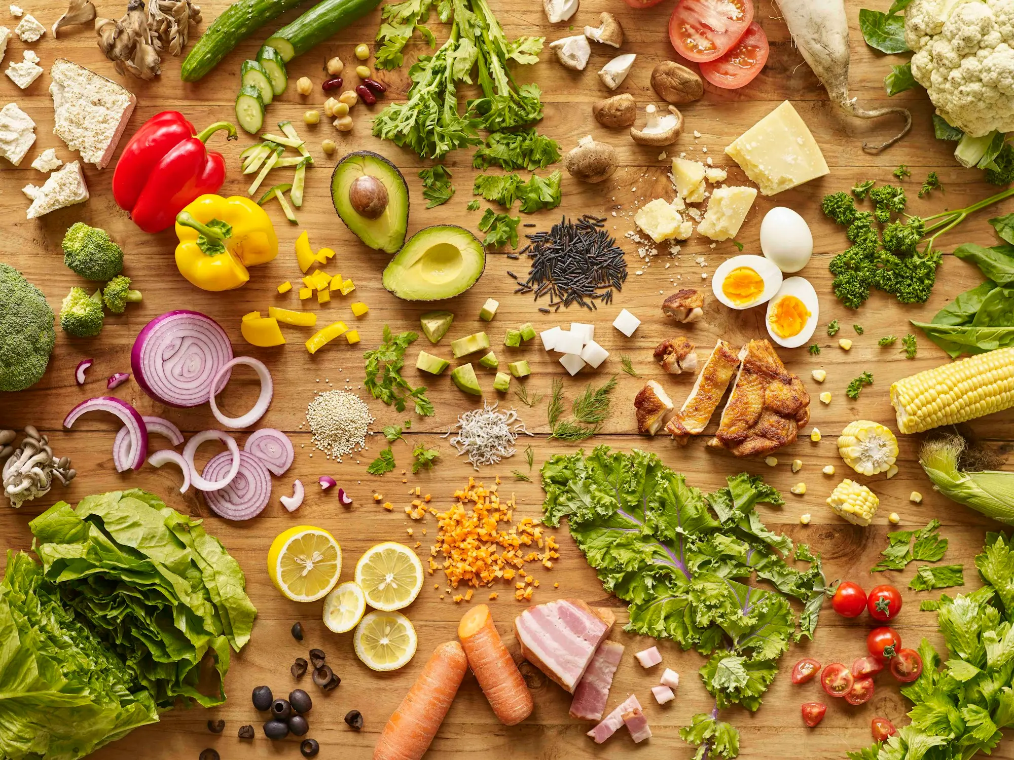 Assortiment d'aliments frais disposés sur bois, avec œufs, fromage, viande, graines et légumes