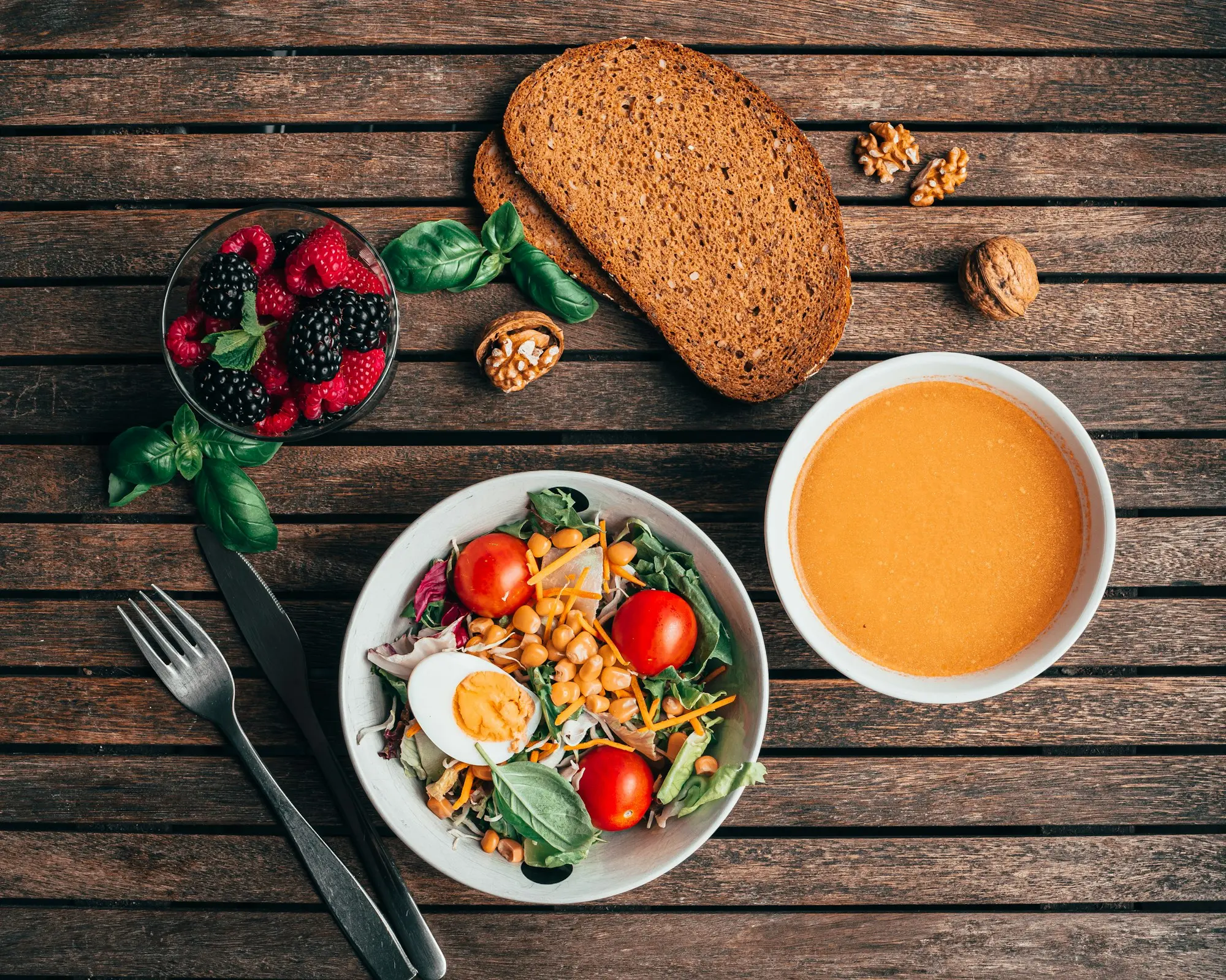 Repas équilibré et léger : salade composée, soupe, pain complet et fruits rouges