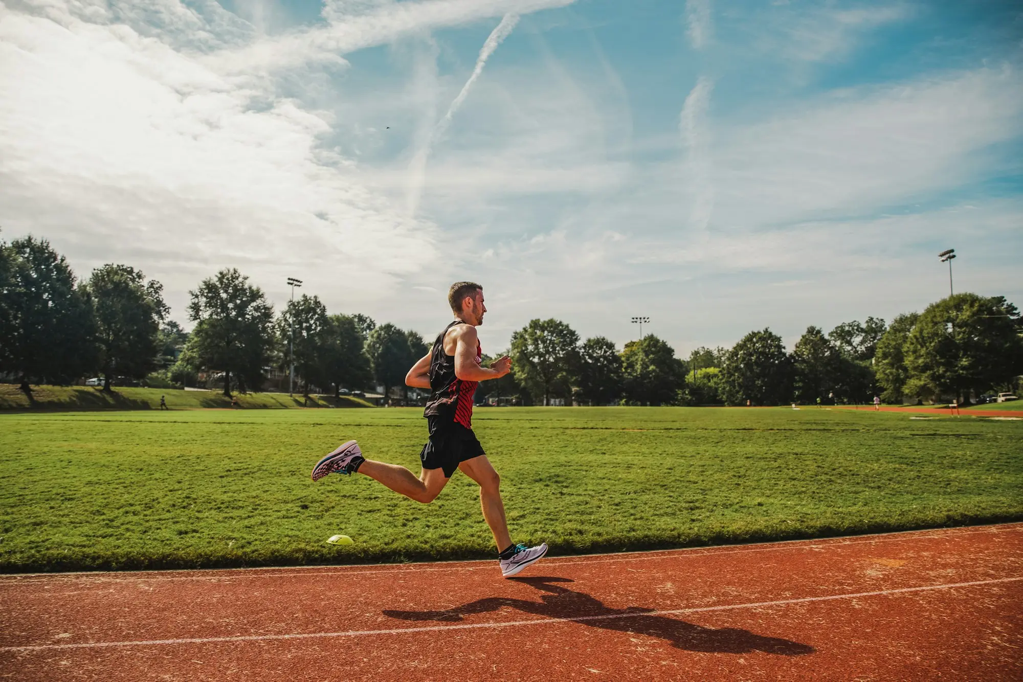 Coureur en pleine accélération sur une piste d'athlétisme, lors d'une séance de fractionné